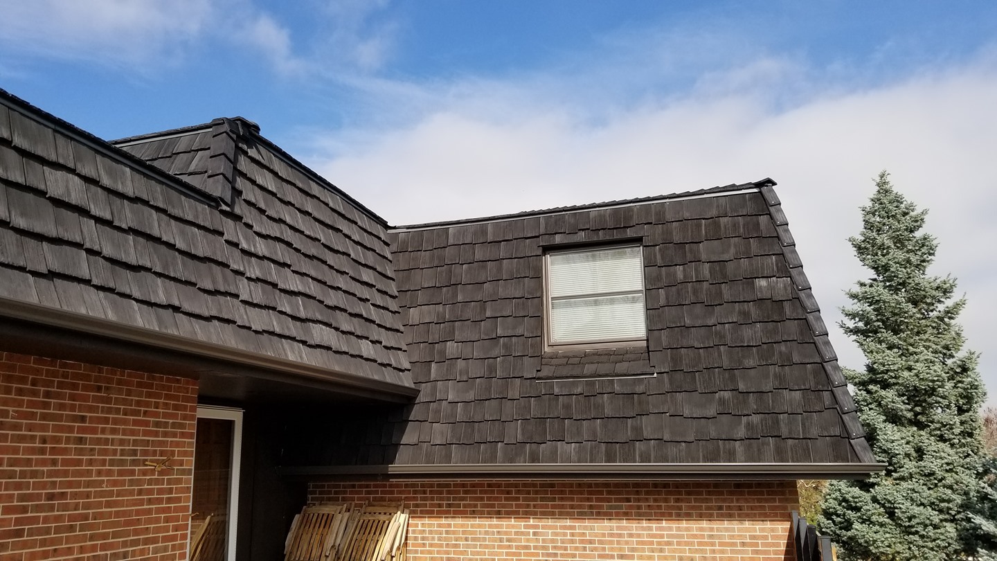 Dark CeDUR synthetic shakes on a red brick mansard roof