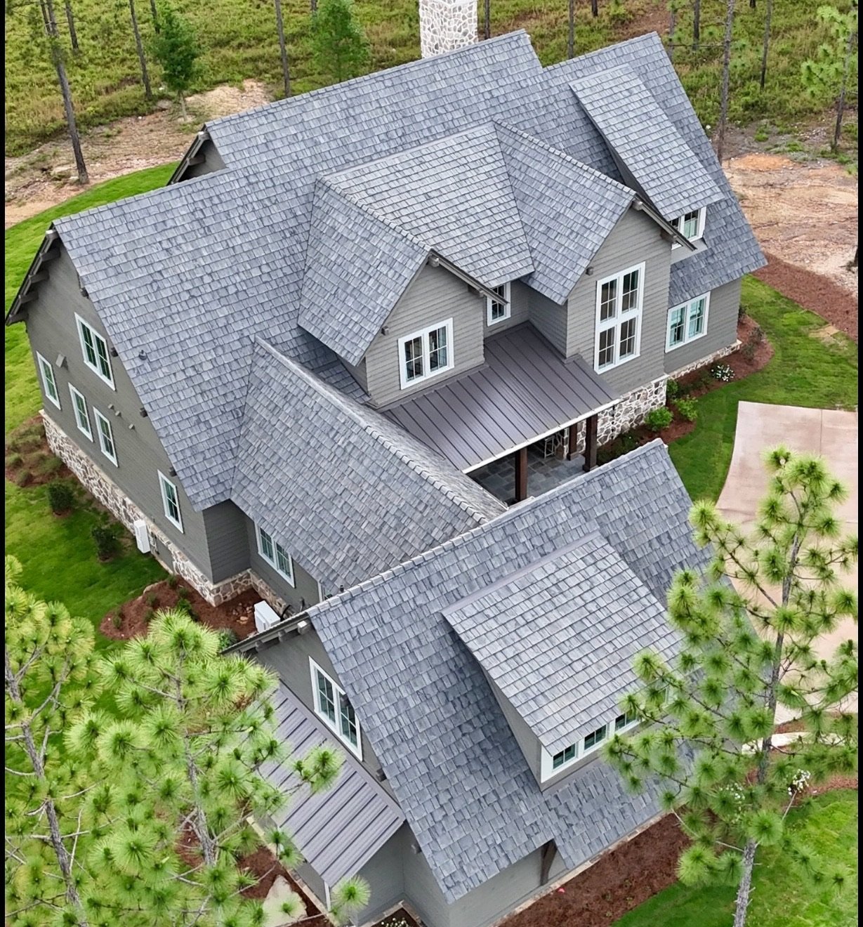 Farmhouse with Brava composite slate roof and metal porch accents, aerial view