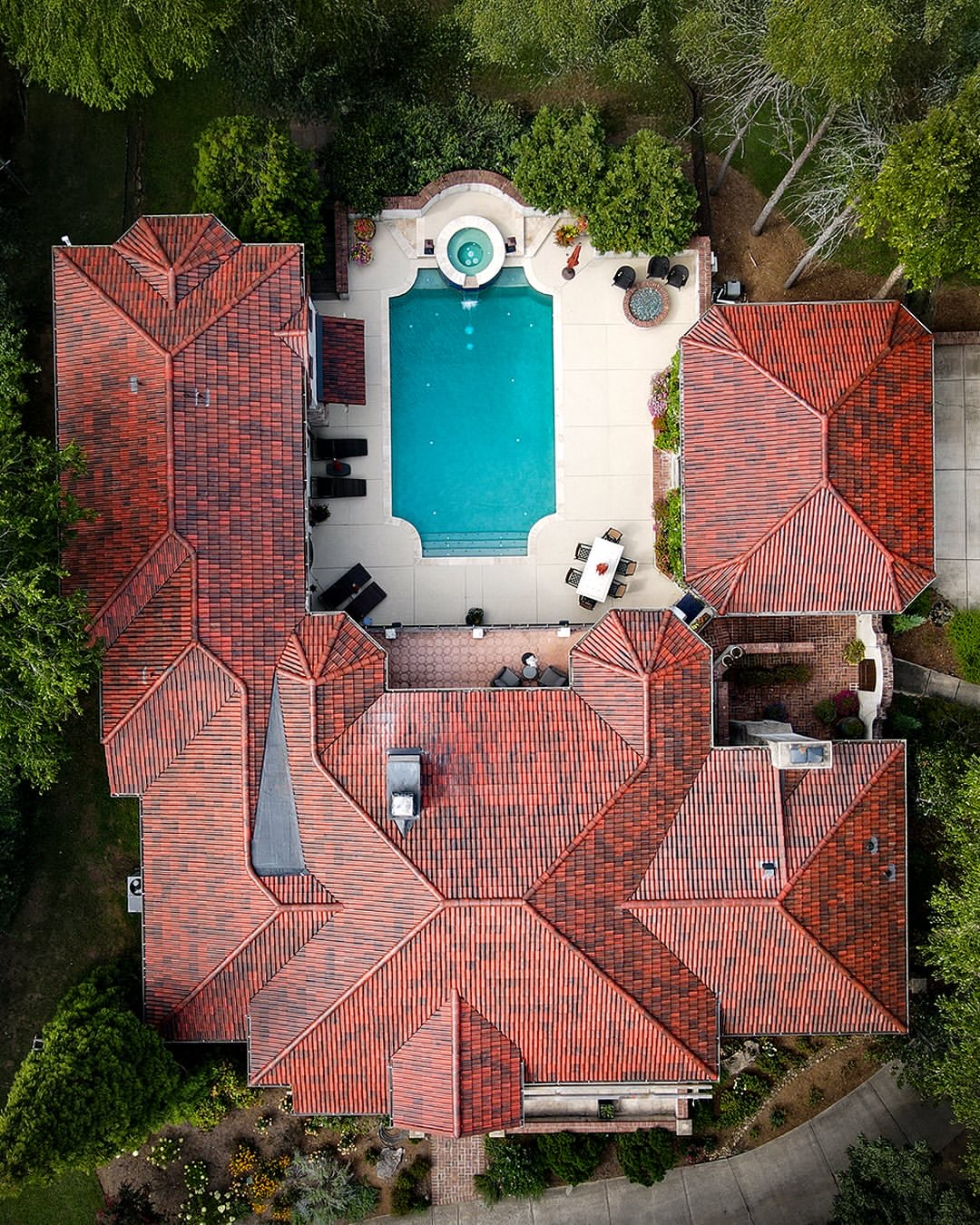 Estate home with red Brava Spanish barrel tile roof and pool, aerial view