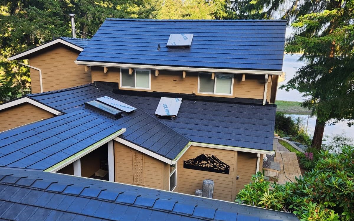 ProVia metal roof installed by HM Roofing on a wooded lakeside home